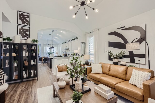 3906 Chesapeake Ln, Crandall, TX 75114 - living area with arched walkways, wood finished floors, a chandelier, and vaulted ceiling