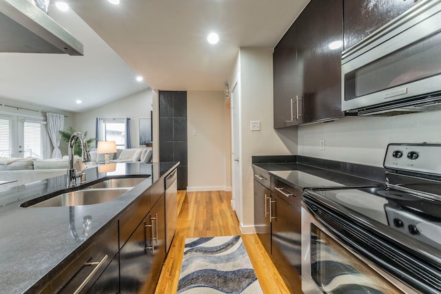 5806 Birchbrook Dr Unit 203, Dallas, TX 75206 - kitchen with stainless steel appliances, a sink, light wood-style floors, open floor plan, and dark stone counters