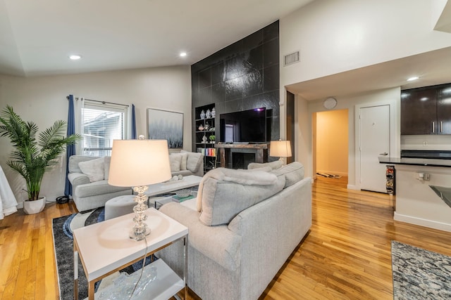 5806 Birchbrook Dr Unit 203, Dallas, TX 75206 - living room featuring light wood-style floors, recessed lighting, high vaulted ceiling, and baseboards