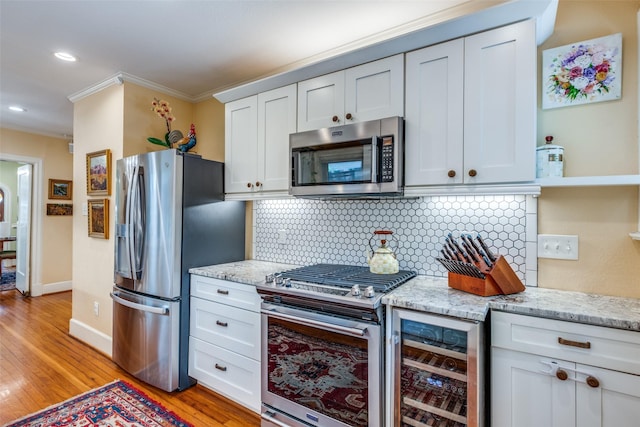 533 Newell Ave, Dallas, TX 75223 - kitchen with appliances with stainless steel finishes, ornamental molding, wine cooler, backsplash, and light wood finished floors