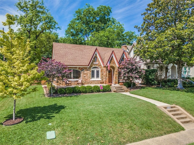 533 Newell Ave, Dallas, TX 75223 - tudor house with stone siding, a front yard, and a chimney