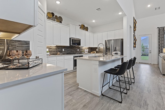 9305 Derry Ln, Aubrey, TX 76227 - kitchen featuring appliances with stainless steel finishes, a sink, light wood finished floors, tasteful backsplash, and recessed lighting
