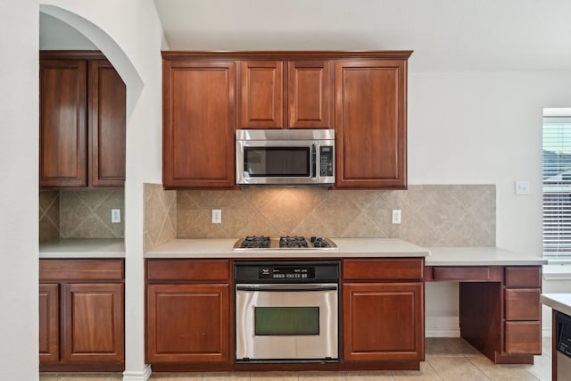 1280 Seymour Dr, Frisco, TX 75034 - kitchen with stainless steel appliances, light countertops, decorative backsplash, and arched walkways