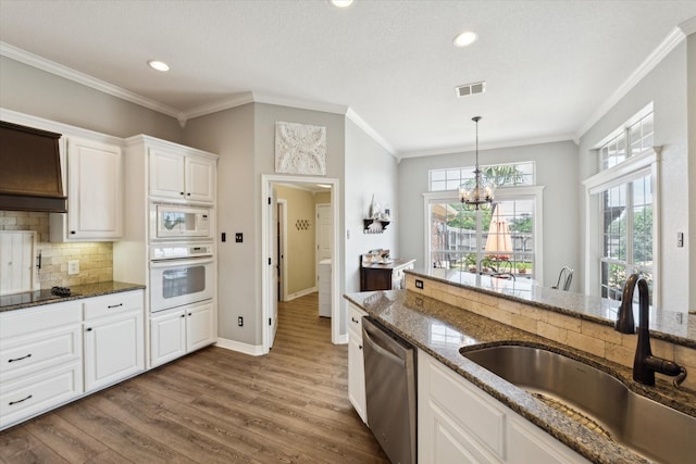 1300 Darbyton Dr, Hewitt, TX 76643 - kitchen with white appliances, a sink, a chandelier, dark stone countertops, and ornamental molding