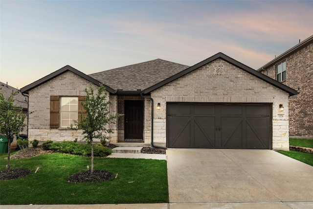 1224 Johnson Dr, Celina, TX 75009 - french country style house featuring an attached garage, concrete driveway, a yard, brick siding, and a shingled roof