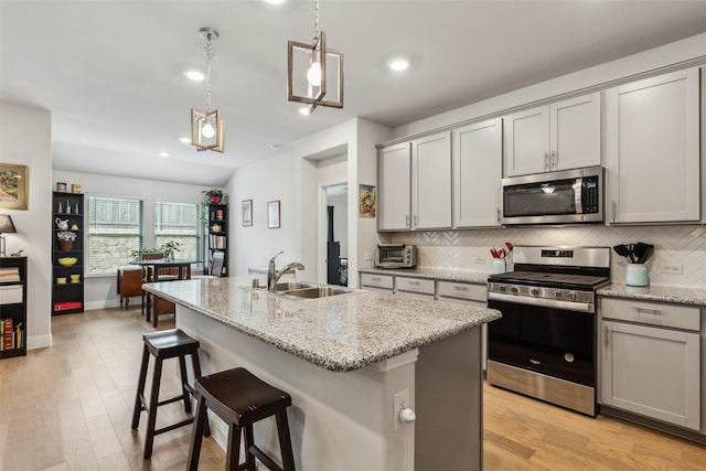 1224 Johnson Dr, Celina, TX 75009 - kitchen featuring appliances with stainless steel finishes, gray cabinetry, a sink, decorative backsplash, and recessed lighting