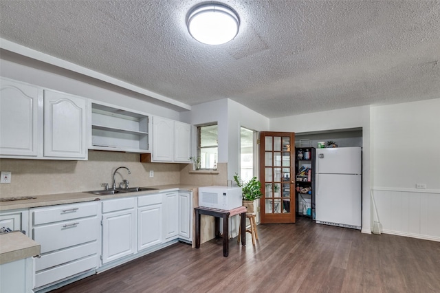 2002 Winthrop St, Irving, TX 75061 - kitchen featuring white appliances, a sink, a textured ceiling, dark wood-type flooring, and light countertops