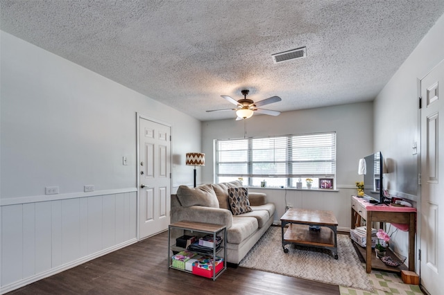 2002 Winthrop St, Irving, TX 75061 - living area featuring wood finished floors, ceiling fan, a textured ceiling, and wainscoting