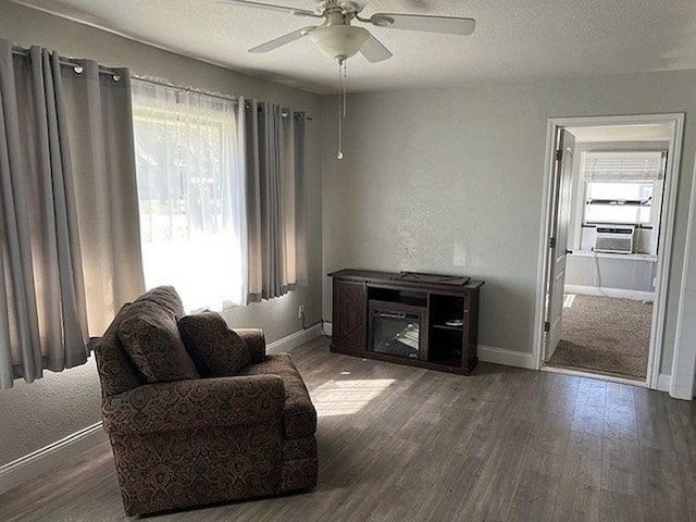 902 N Church St, Decatur, TX 76234 - sitting room with baseboards, a ceiling fan, wood finished floors, a textured ceiling, and cooling unit