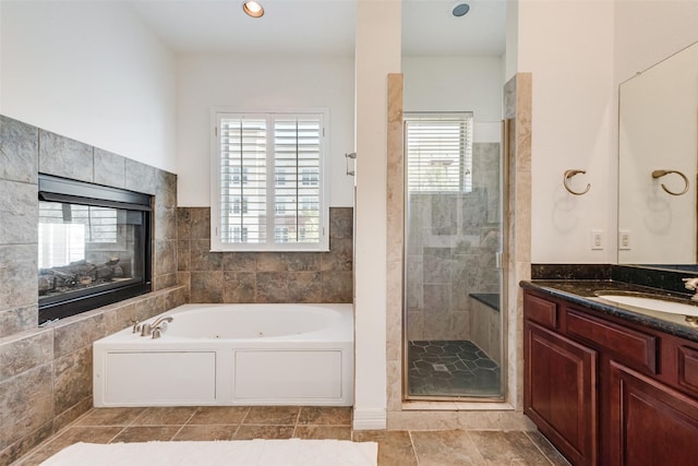 1400 Clarinet Ln, Plano, TX 75074 - bathroom with a tub with jets, a stall shower, vanity, tile patterned floors, and a tiled fireplace