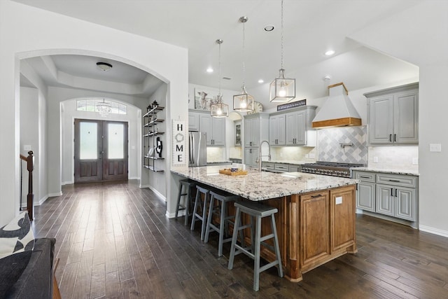 163 Las Colinas Trl, Cross Roads, TX 76227 - kitchen featuring premium range hood, freestanding refrigerator, arched walkways, baseboards, and dark wood-style floors