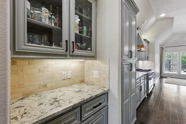 163 Las Colinas Trl, Cross Roads, TX 76227 - kitchen with stainless steel stove, gray cabinets, light stone counters, custom exhaust hood, and dark wood-style floors