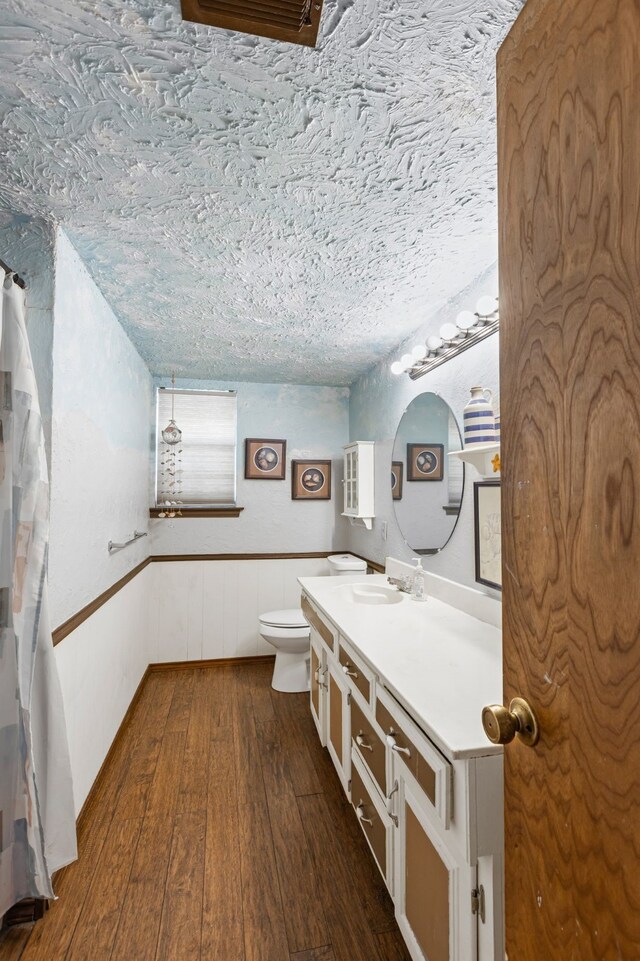 100 Yorkshire Dr, Princeton, TX 75407 - bathroom with vanity, hardwood / wood-style floors, wainscoting, toilet, and a textured ceiling