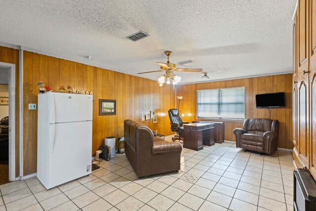 100 Yorkshire Dr, Princeton, TX 75407 - living room with wooden walls, an office area, ceiling fan, light tile patterned flooring, and a textured ceiling