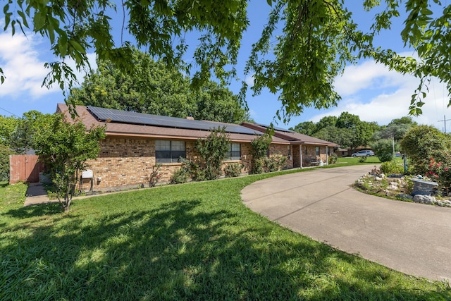 100 Yorkshire Dr, Princeton, TX 75407 - ranch-style house with roof mounted solar panels, brick siding, and concrete driveway