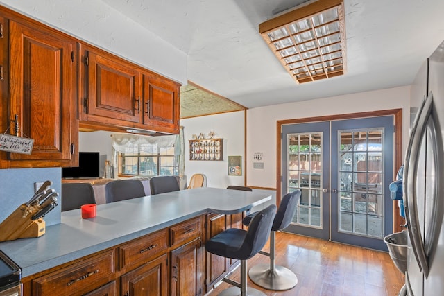 100 Yorkshire Dr, Princeton, TX 75407 - kitchen featuring a kitchen bar, french doors, freestanding refrigerator, and light wood-type flooring