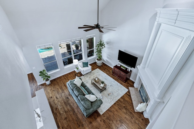 8905 Glen Garden Dr, Mckinney, TX 75072 - living room with ceiling fan, a high ceiling, wood finished floors, and a fireplace with flush hearth