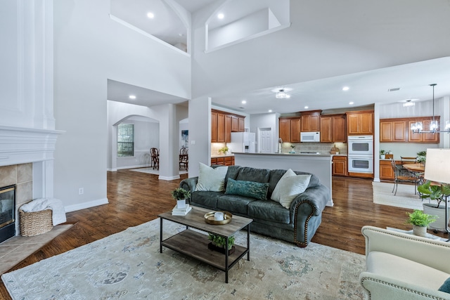 8905 Glen Garden Dr, Mckinney, TX 75072 - living area featuring wood finished floors, arched walkways, recessed lighting, a fireplace, and baseboards