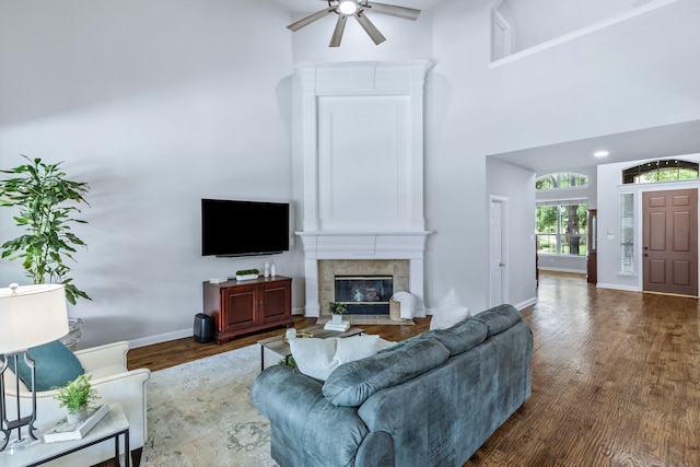 8905 Glen Garden Dr, Mckinney, TX 75072 - living area with ceiling fan, wood finished floors, a high ceiling, baseboards, and a tile fireplace