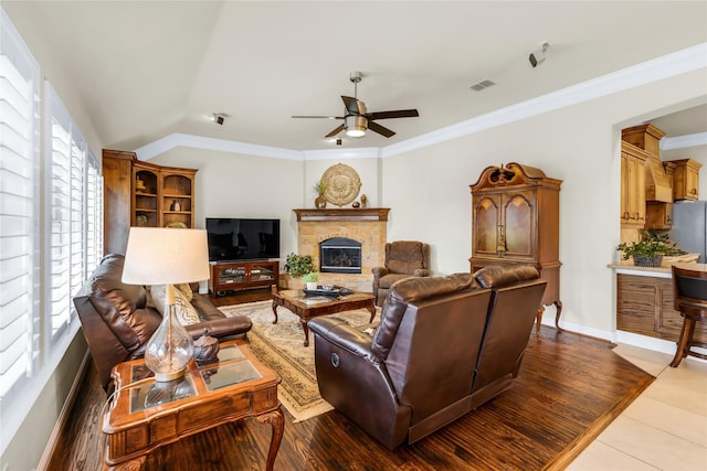 7100 King Ranch Rd, North Richland Hills, TX 76182 - tiled living area featuring ceiling fan, a glass covered fireplace, ornamental molding, vaulted ceiling, and baseboards