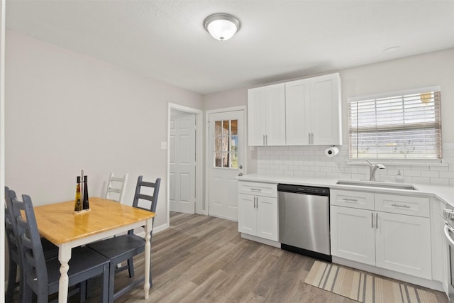 1503 Dale Dr, Arlington, TX 76010 - kitchen with stainless steel dishwasher, a sink, decorative backsplash, and white cabinetry
