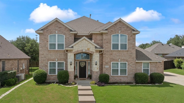 103 Daisey Ln, Justin, TX 76247 - traditional home with brick siding, a shingled roof, and cooling unit