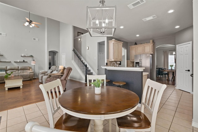 103 Daisey Ln, Justin, TX 76247 - dining room with arched walkways, light tile patterned floors, a ceiling fan, stairs, and recessed lighting