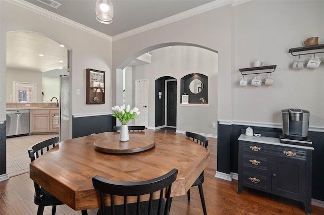 103 Daisey Ln, Justin, TX 76247 - dining area featuring arched walkways, ornamental molding, and light wood-style floors