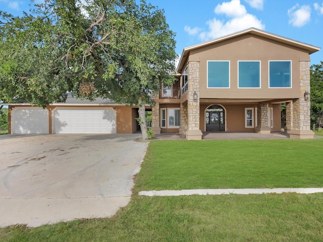 710 Crows Pt, Lake Bridgeport, TX 76426 - view of front of home featuring stucco siding, stone siding, a balcony, a front lawn, and driveway