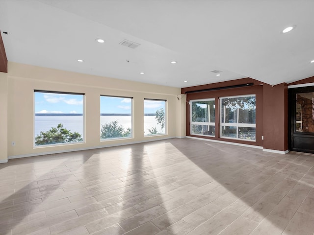 710 Crows Pt, Lake Bridgeport, TX 76426 - unfurnished living room with baseboards, light wood-style flooring, recessed lighting, and a water view