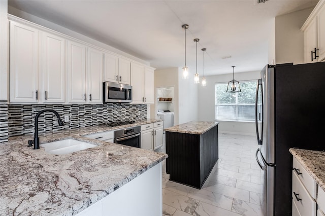 1531 Winding Trail Dr, Allen, TX 75002 - kitchen featuring appliances with stainless steel finishes, a center island, backsplash, and white cabinetry