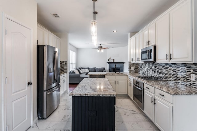 1531 Winding Trail Dr, Allen, TX 75002 - kitchen featuring stainless steel appliances, open floor plan, light marble finish flooring, ceiling fan, and a kitchen island