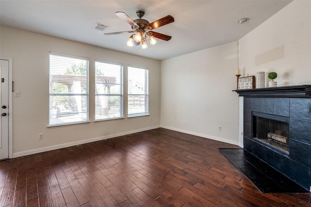 1531 Winding Trail Dr, Allen, TX 75002 - unfurnished living room with a ceiling fan, dark wood-style flooring, a tiled fireplace, and baseboards