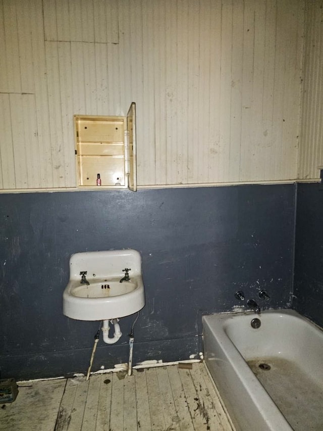 823 W Louisiana St, Palestine, TX 75801 - full bathroom with a tub, hardwood / wood-style flooring, a sink, and wood walls