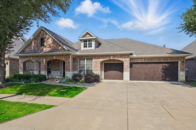 9352 Blanco Dr, Lantana, TX 76226 - view of front facade with brick siding, a garage, concrete driveway, a front yard, and a shingled roof