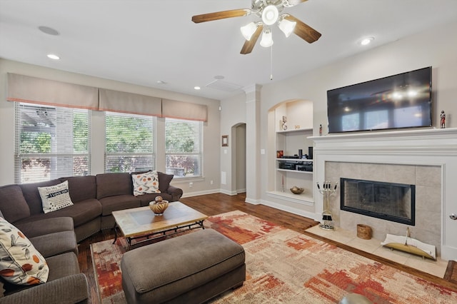 9352 Blanco Dr, Lantana, TX 76226 - living room featuring arched walkways, ceiling fan, built in features, wood finished floors, and baseboards