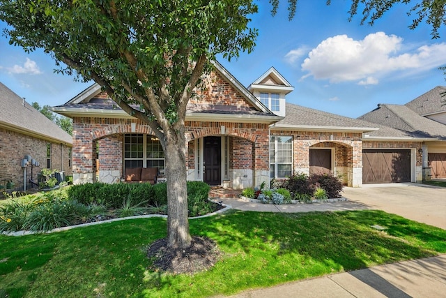 9352 Blanco Dr, Lantana, TX 76226 - view of front of home with brick siding, a front lawn, an attached garage, driveway, and roof with shingles