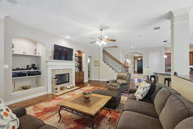 9352 Blanco Dr, Lantana, TX 76226 - living room with arched walkways, built in shelves, a ceiling fan, stairs, and wood finished floors