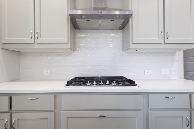 12978 Caprock Dr, Frisco, TX 75035 - kitchen with under cabinet range hood, backsplash, light countertops, and stainless steel gas cooktop