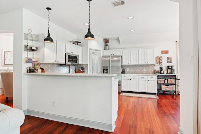 921 Stoneway Dr, Denton, TX 76210 - kitchen featuring appliances with stainless steel finishes, backsplash, wood finished floors, white cabinets, and recessed lighting
