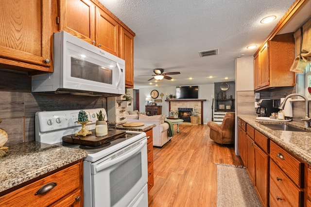 6171 Inca Dr, Mabank, TX 75156 - kitchen featuring white appliances, a sink, ceiling fan, light wood finished floors, and brown cabinetry