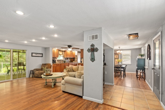 6171 Inca Dr, Mabank, TX 75156 - living area with light wood-type flooring, plenty of natural light, a textured ceiling, recessed lighting, and a chandelier
