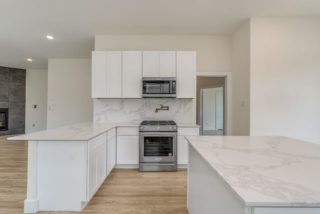 821 Hearthside Way, Mckinney, TX 75071 - kitchen featuring stainless steel appliances, light wood-style flooring, a peninsula, recessed lighting, and white cabinetry