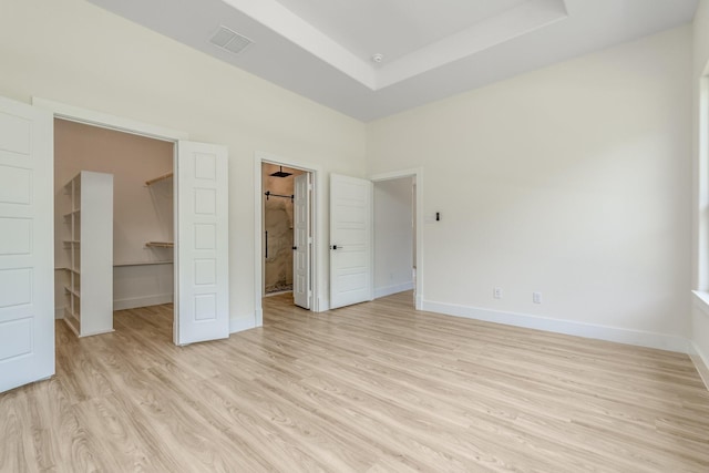821 Hearthside Way, Mckinney, TX 75071 - unfurnished bedroom with a spacious closet, light wood-type flooring, baseboards, a closet, and connected bathroom