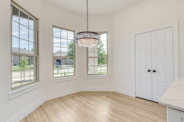 821 Hearthside Way, Mckinney, TX 75071 - unfurnished dining area featuring a chandelier, light wood-type flooring, plenty of natural light, and baseboards