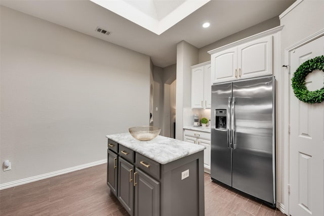 5536 Green Hollow Ln, The Colony, TX 75056 - kitchen featuring stainless steel fridge, white cabinets, light countertops, a center island, and light wood finished floors