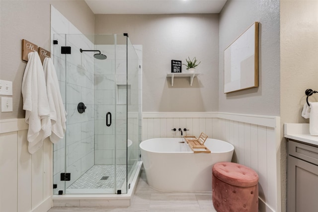 5536 Green Hollow Ln, The Colony, TX 75056 - full bathroom featuring a freestanding bath, a stall shower, vanity, and a wainscoted wall