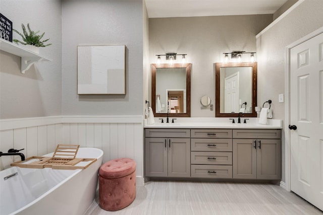 5536 Green Hollow Ln, The Colony, TX 75056 - full bath featuring double vanity, a freestanding tub, and a wainscoted wall