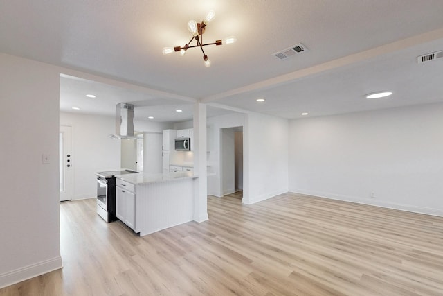 1426 S Beckley Ave, Dallas, TX 75224 - kitchen with appliances with stainless steel finishes, island exhaust hood, white cabinetry, light wood-type flooring, and a chandelier