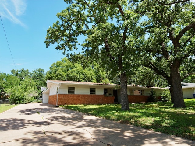 1431 Brazos St, Graham, TX 76450 - ranch-style home featuring brick siding, concrete driveway, and a front lawn